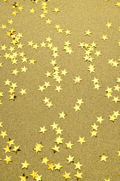 Confetti con forma de estrellas brillantes amarillas sobre fondo de brillantina amarillo