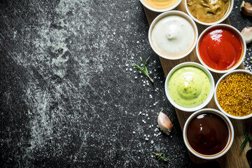 Different sauces in the bowls on the cutting Board.