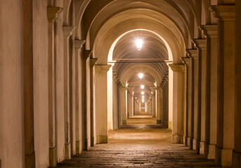 arcade with arcades that seem to go on forever with the streetlights on at night