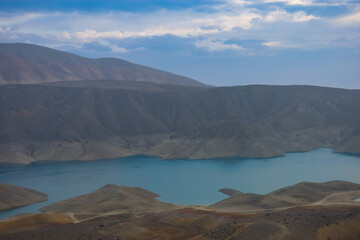 Azat reservoir with Yeranos mountain range in the background. Beautiful dramatic colorful cloudy sunset in a rocky canyon.