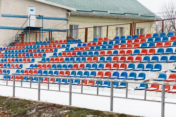 Places where fans sit, plastic chairs in a football stadium, in winter