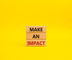 Make an impact symbol. Concept word Make an impact on wooden blocks. Beautiful yellow background. Business and Make an impact concept. Copy space