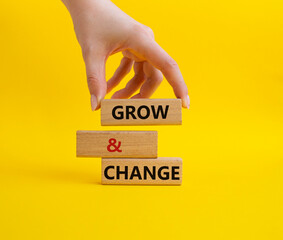 Grow and Change symbol. Concept word Grow and Change on wooden blocks. Businessman hand. Beautiful yellow background. Business and Grow and Change concept. Copy space