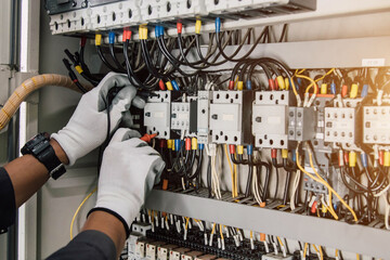 Electrician engineer tests electrical installations and wires on relay protection system.