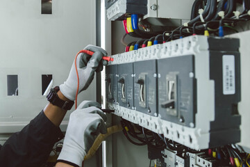 Electrician engineer tests electrical installations and wires on relay protection system.
