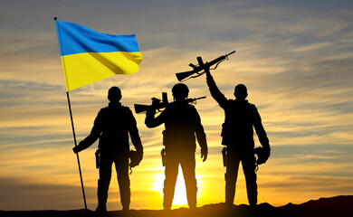 Silhouettes of soldiers with Ukraine flag against the sunset. Armed forces of Ukraine concept. EPS10 vector