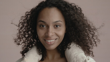 CU Headshot portrait of beautiful 20s African-American Black female posing against brown...