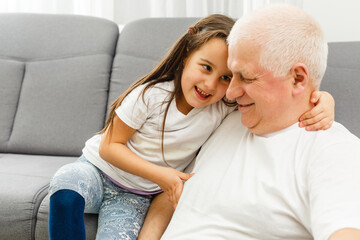 Photo of funny two people old grandpa little granddaughter sitting comfort sofa telling good story...