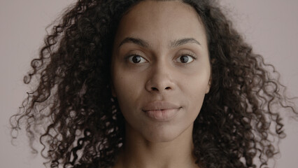CU Headshot portrait of beautiful 20s African-American Black female posing against brown...