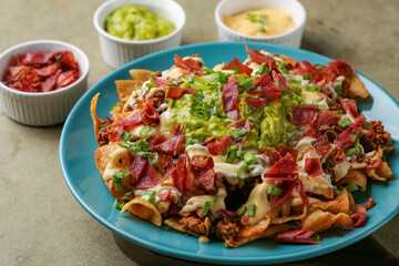 Rich nachos with meat and Italian sausage, 5 cheese sauce, guacamole, Mexican-style sour cream