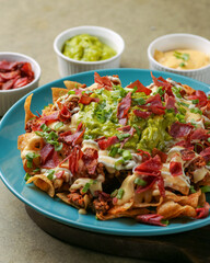 Rich nachos with meat and Italian sausage, 5 cheese sauce, guacamole, Mexican-style sour cream