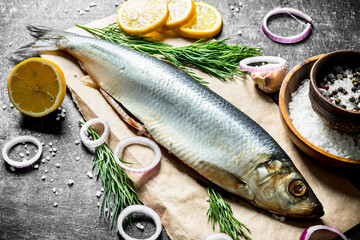 Delicious salted herring with slices of lemon, onion and herbs.