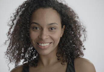 CU Headshot portrait of beautiful 20s African-American Black female posing against white...