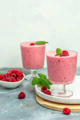 Yogurt smoothie with raspberries in glass on light table. weight loss concept. vertical image. place for text