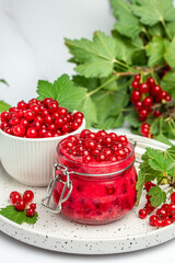 Preserved berry Homemade jam. Glass jar with red currant jam on a light background. vertical image. top view. place for text