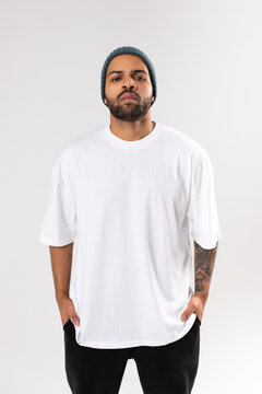 Stylish african american man in a white t-shirt stands a white background. Mock-up.