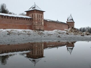 old red bricks castle in the snow reflected in water