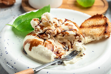 Creamy Italian Burrata Cheese on a light background. top view