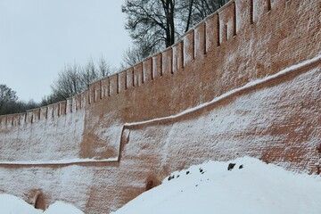 snow covered old red bricks wall of castle