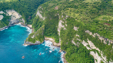 Beautiful coastline aerial view from Saren Cliff Point. Clear water and rocks with cloudy sky. Nusa Penida, Indonesia.