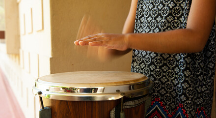 hands of little girl playing the drum faster and making loud music and enjoying it