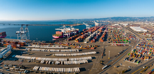 The Oakland Outer Harbor aerial view. Loaded trucks moving by Container cranes. View of busy Port...