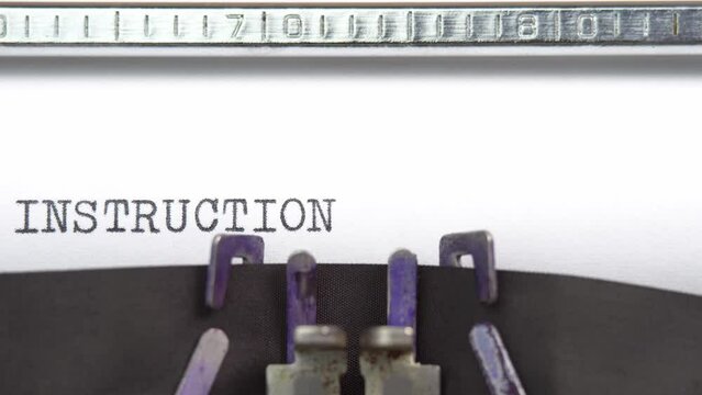 Instruction word closeup being typing and centered on a sheet of paper on old vintage typewriter mechanical