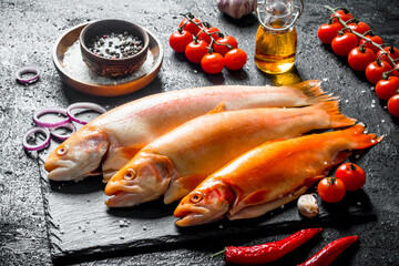 Raw fish trout with chili pepper, cherry tomatoes and spices.