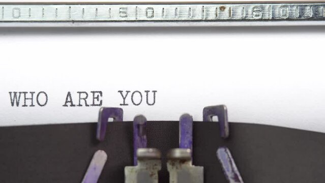 Who Are You phrase closeup being typing and centered on a sheet of paper on old vintage typewriter mechanical