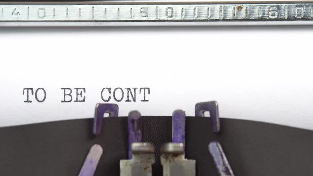 To Be Continued phrase closeup being typing and centered on a sheet of paper on old vintage typewriter mechanical