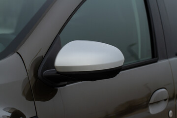 Close up front view of car side mirror. Front rear view mirror on the car window. Car exterior details.