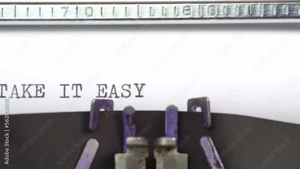 Aufkleber take it easy phrase closeup being typing and centered on a sheet of paper on old vintage typewriter 