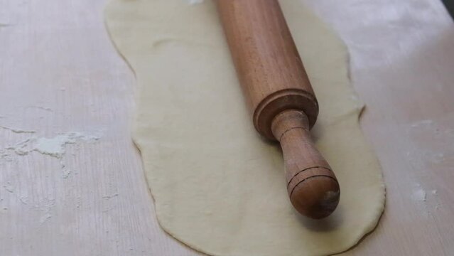 rolling pin downloaded dough for pies or pizza close-up on Light table how much is first put on dough it is removed cooking at home in restaurants handmade pastry cooking space for text and ad