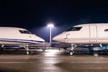 Private jet parked at night, making an elegant aviation background. Business jet is the way to...