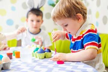 Happy Easter. Children dye colorful egg for Easter hunt