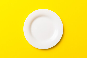 Top view of isolated of colored background empty round white plate for food. Empty dish with space for your design