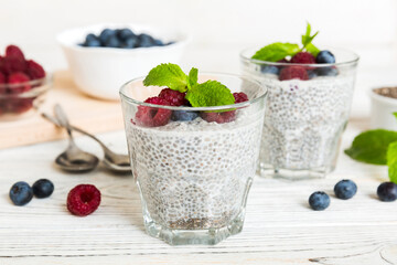 Healthy breakfast or morning with chia seeds vanilla pudding raspberry and blueberry berries on table background, vegetarian food, diet and health concept. Chia pudding with raspberry and blueberry
