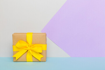 holiday paper present tied yellow ribbon bow top view with copy space. Flat lay holiday background. Birthday or christmas present. Christmas gift box concept with copy space