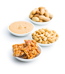 Sweet peanut brittle, peanuts and peanuts butter isolated on white background.