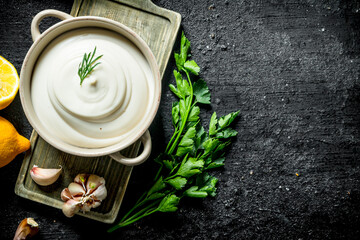 Mayonnaise on a cutting Board with lemon and parsley.
