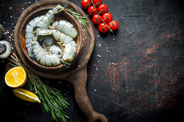 Whole shrimps raw on a plate with spices, tomatoes and lemon.
