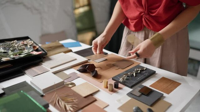 Woman architect puts samples on a table in the office