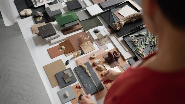 Overhead view of female architect puts samples on a table in the office