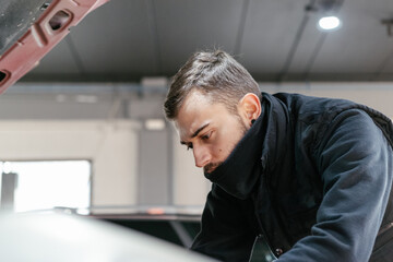 Obraz premium Car mechanic working in a garage