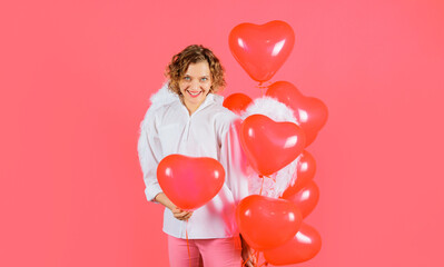 Happy Valentines day. Smiling woman in angelic wings with red heart balloons.
