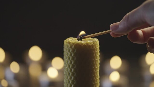Cinematic candle lighting close-up. Female hands light a candle in the dark. The atmosphere of romance and love. Preparing for a romantic dinner. High quality 4k footage