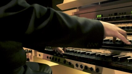 Performing on pipe organ, keyboard music instrument. Hands of organist on keys, playing melody. Musician solo at concert