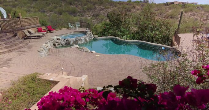 Swimming pool with hot tub and terraced patio at a luxury home in a desert environment.