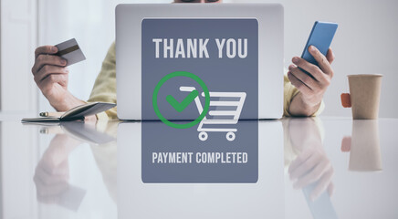 Man behind computer, purchase and pay online. Credit card and smartphone in hand. Payment completed.