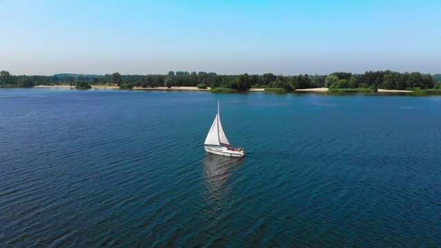 Aerial tracking drone shot of a sailboat on a lake in Zeewolde, The Netherlands